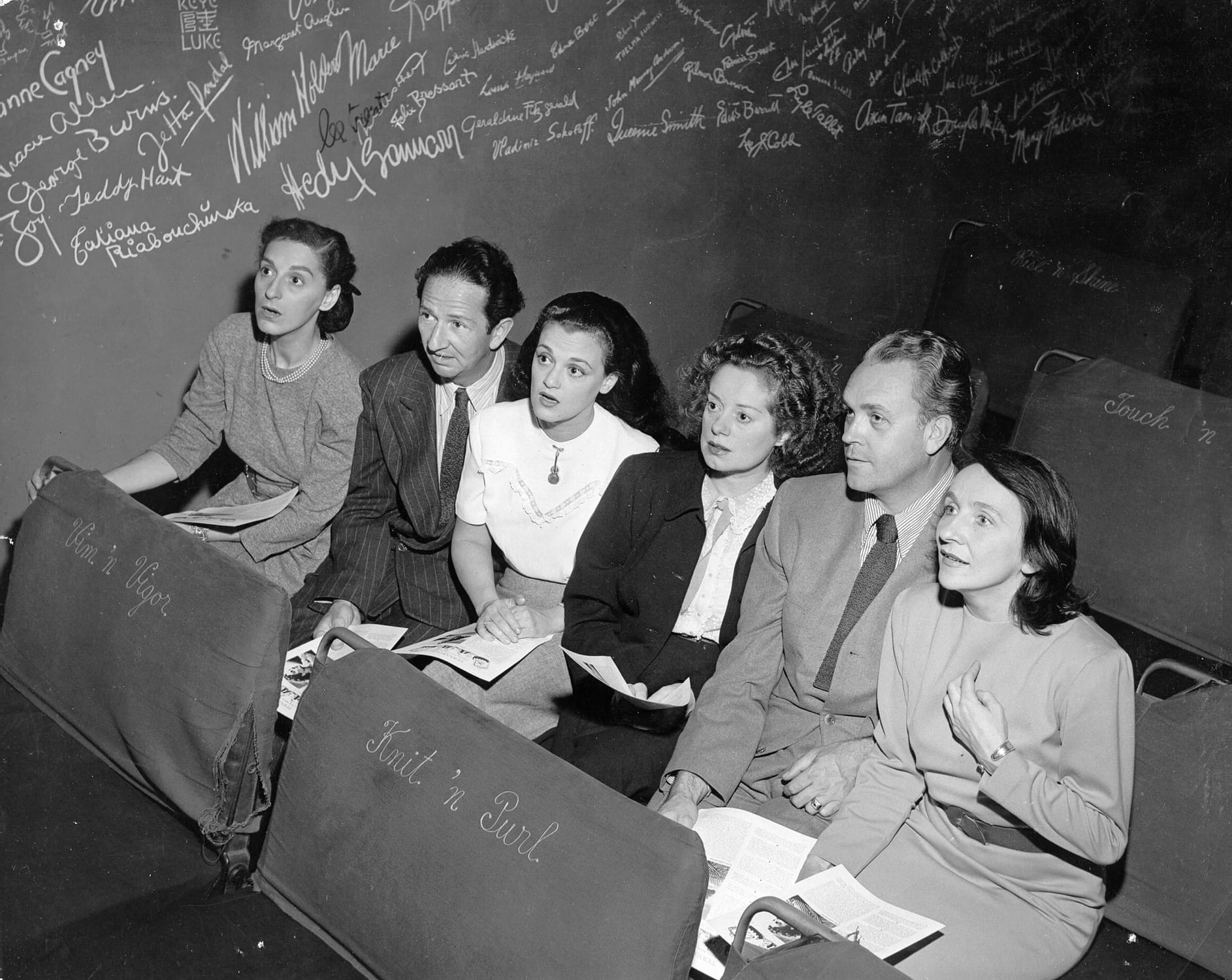 Dorothy Neumann, Harry Burnett, Frances Osborne, Elsa Lanchester, Forman Brown, and Lotte Gosler sit in the Turnabout Theater, with the autograph wall in the background.