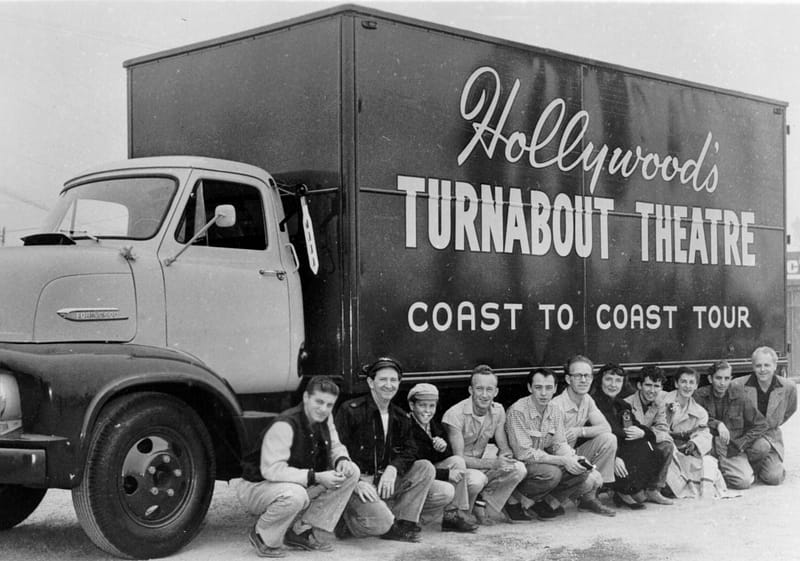 Cast and crew of Thruabout Theater pose for a photo along the side of their large show truck